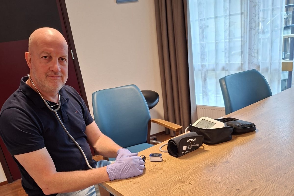 Willem aan tafel met zijn apparatuur, met een agenda waarin de afspraak gepland staat